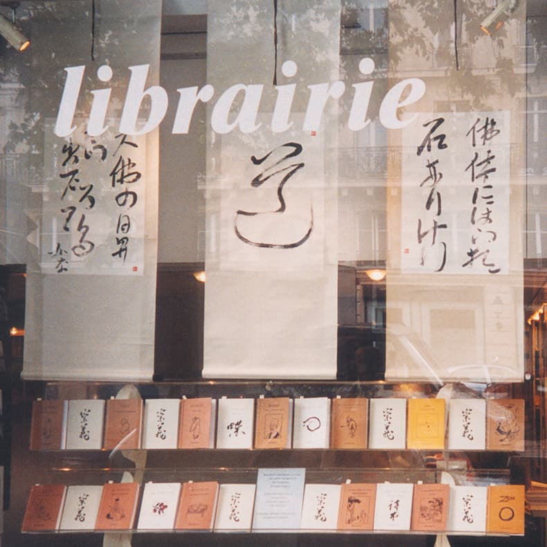 Photo de livres et de rouleaux calligraphiés exposés à la librairie la Hune